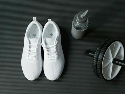 Sport shoes and a water bottle on a gym floor
